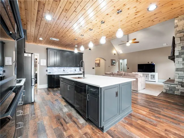 a large kitchen with stainless steel appliances kitchen island granite countertop a large counter top and stove
