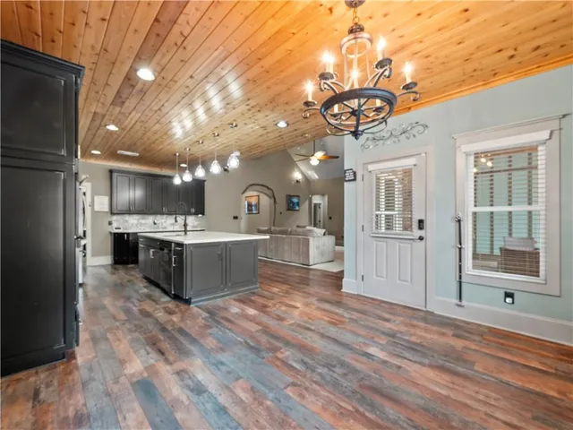a large white kitchen with a refrigerator a sink dishwasher and a fireplace with wooden floor