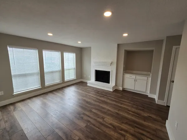a view of an empty room with a fireplace and a window