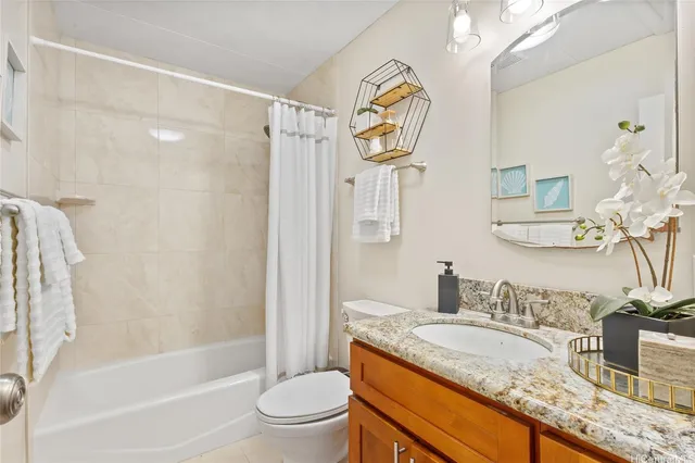 a bathroom with a granite countertop sink mirror vanity and toilet