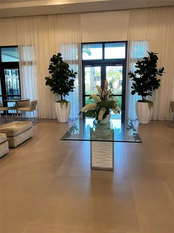 a living room with furniture and potted plants
