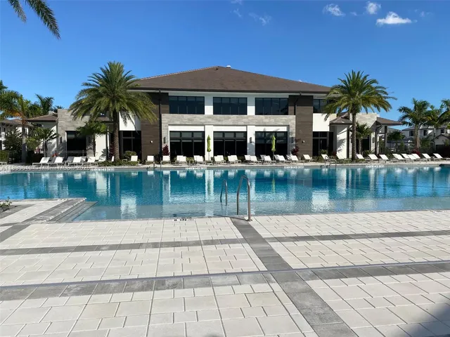 a front view of a house with swimming pool and a yard