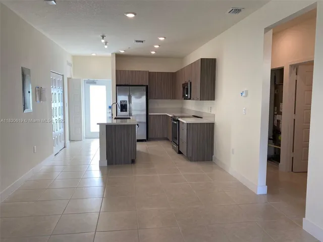 a kitchen with stainless steel appliances granite countertop a refrigerator and a stove top oven