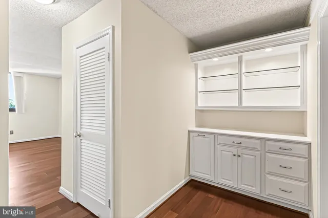 a view of a room with wooden floor and white walls