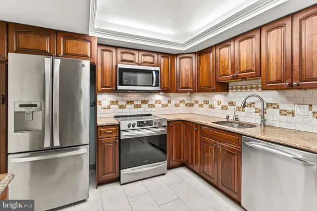 a kitchen with stainless steel appliances granite countertop a stove sink microwave and cabinets