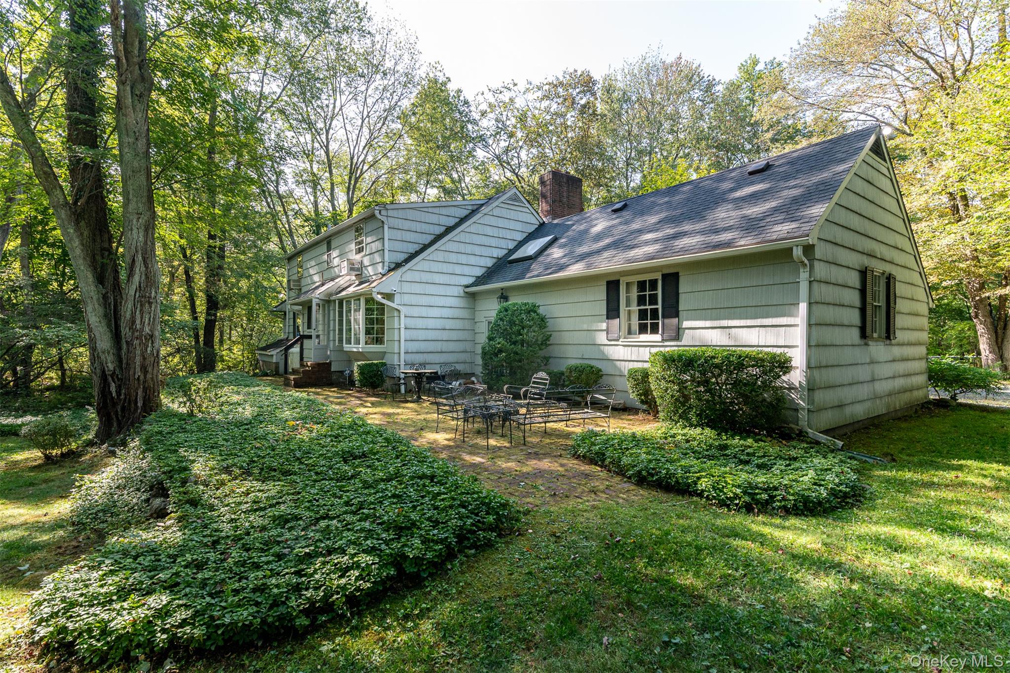 5 Hadley Road Armonk, NY 10504 - Photo 11 of 18 a backyard of a house with plants and large tree