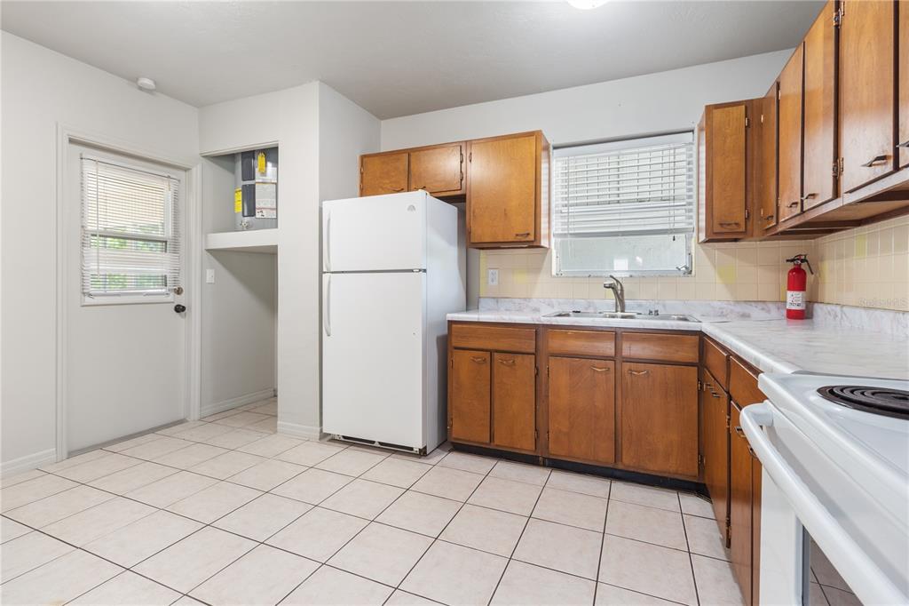 7208 Fair Oaks Street Spring Hill, FL 34606 - Photo 9 of 25 a kitchen with a sink a refrigerator and cabinets