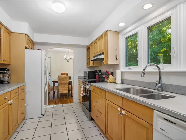 a kitchen with stainless steel appliances a sink window and cabinets
