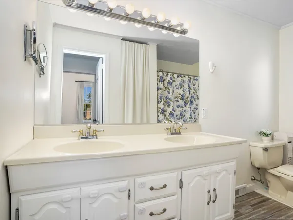 a bathroom with a sink vanity mirror and toilet