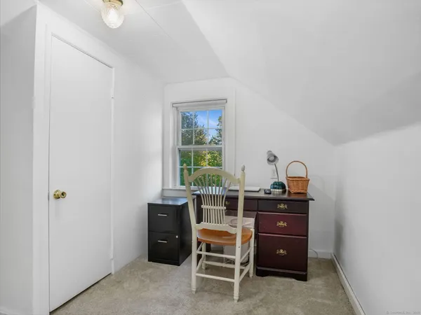 a view of a workspace with furniture and window