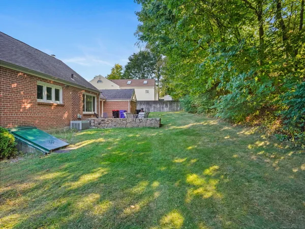 a front view of a house with a yard and green space