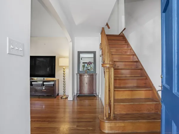 a view of a livingroom with wooden floor and stairs