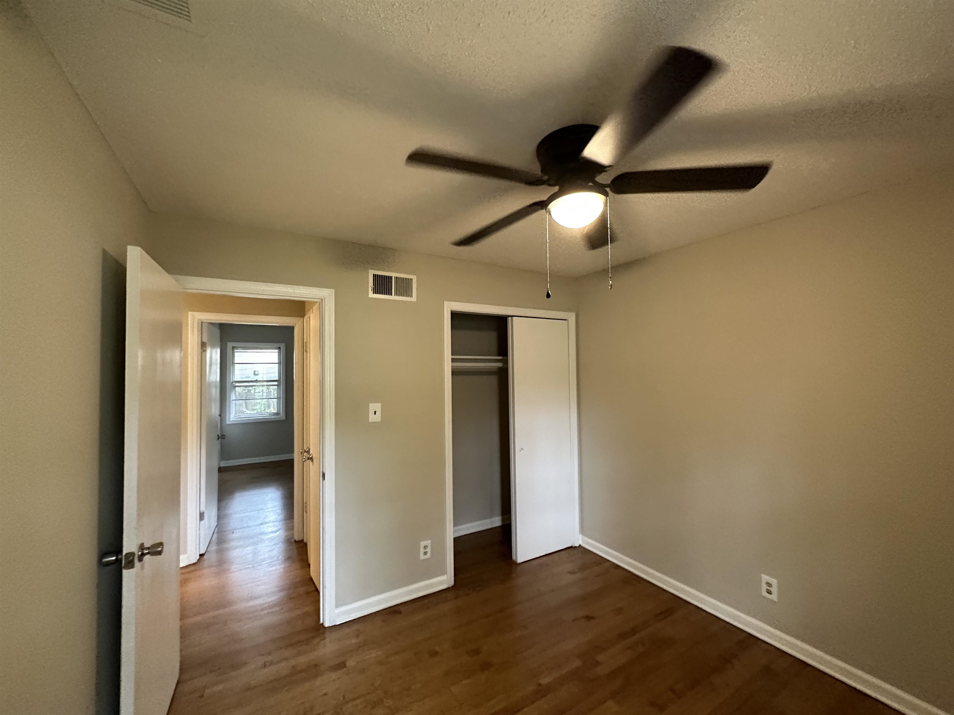 1594 Winfield Road Memphis, TN 38116 - Photo 19 of 29 an empty room with wooden floor fan and windows