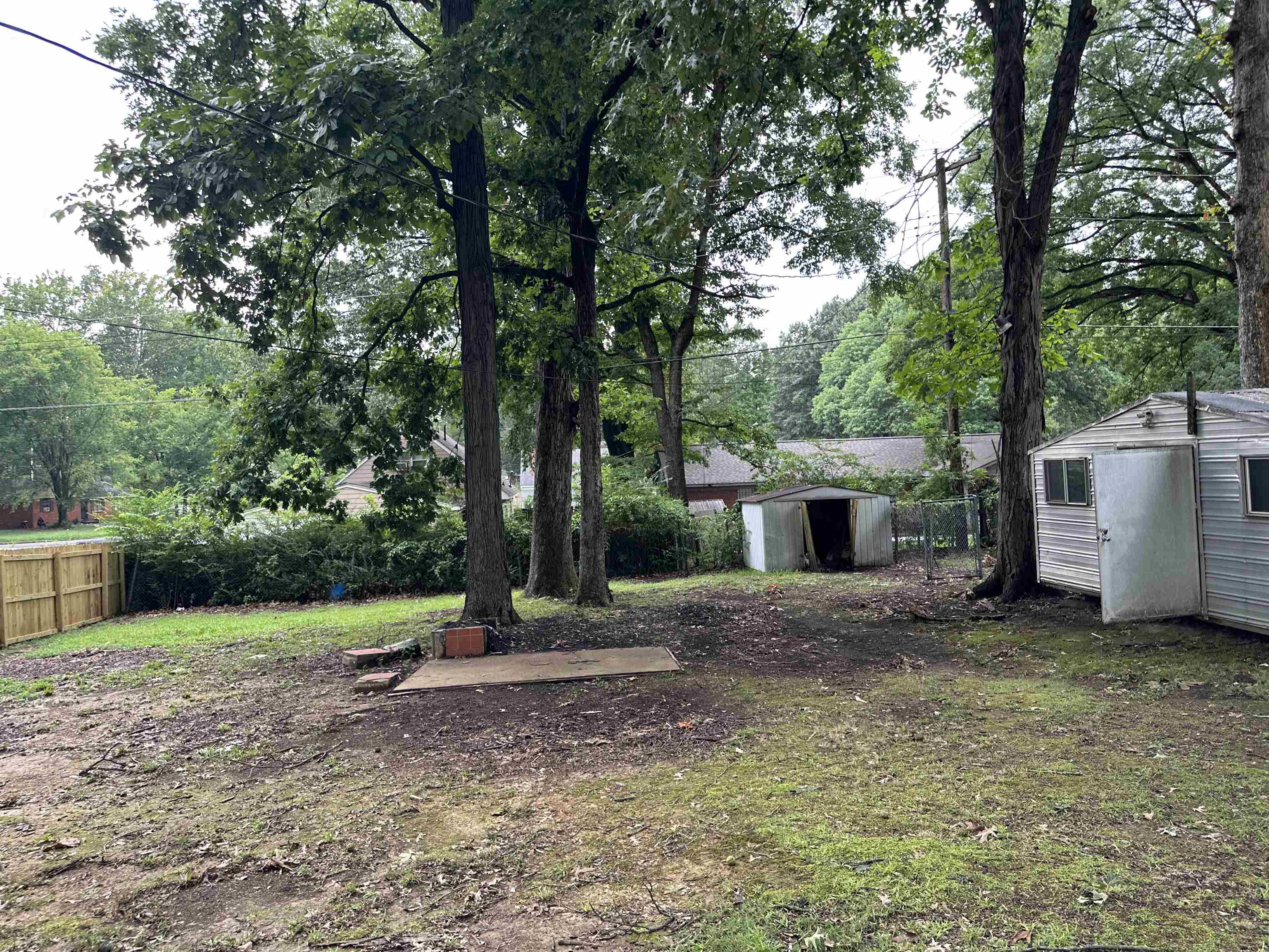 1594 Winfield Road Memphis, TN 38116 - Photo 26 of 29 a backyard of a house with wooden fence and large trees