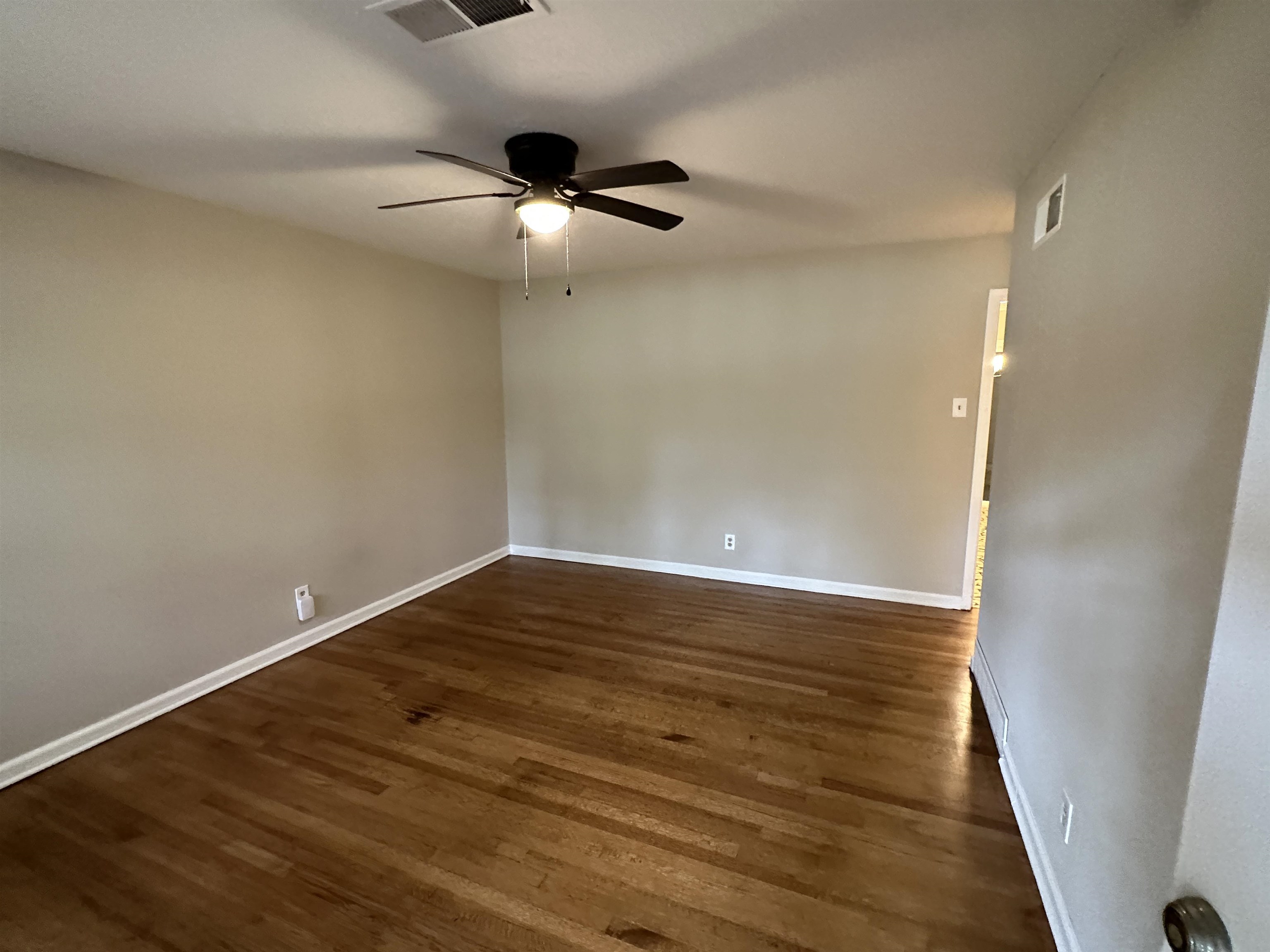 1594 Winfield Road Memphis, TN 38116 - Photo 3 of 29 an empty room with wooden floor cabinet and ceiling fan