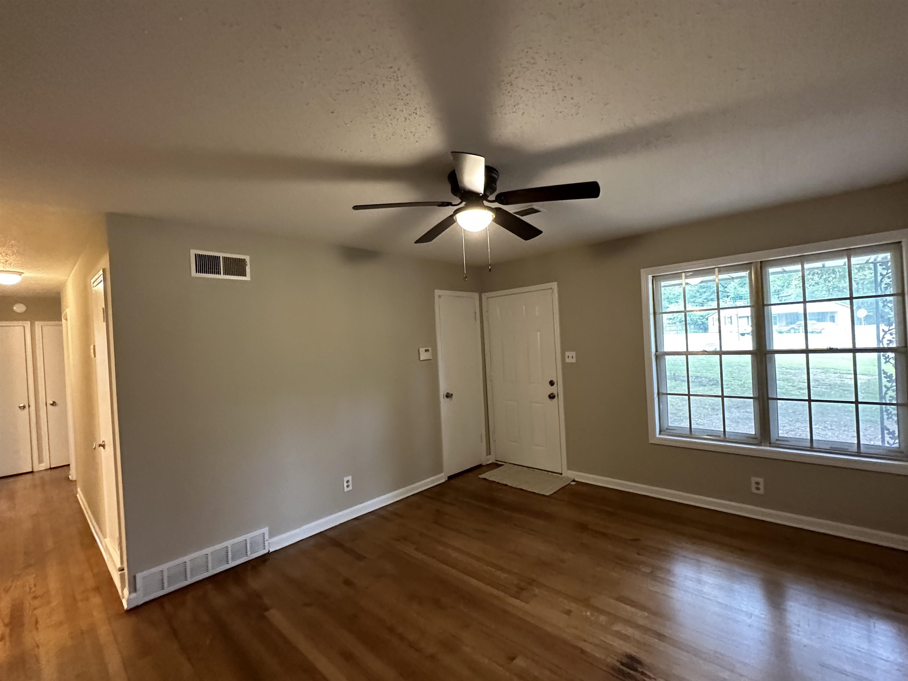 1594 Winfield Road Memphis, TN 38116 - Photo 5 of 29 a view of an empty room with window and wooden floor
