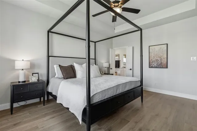 a bedroom with a bed dresser and a large window