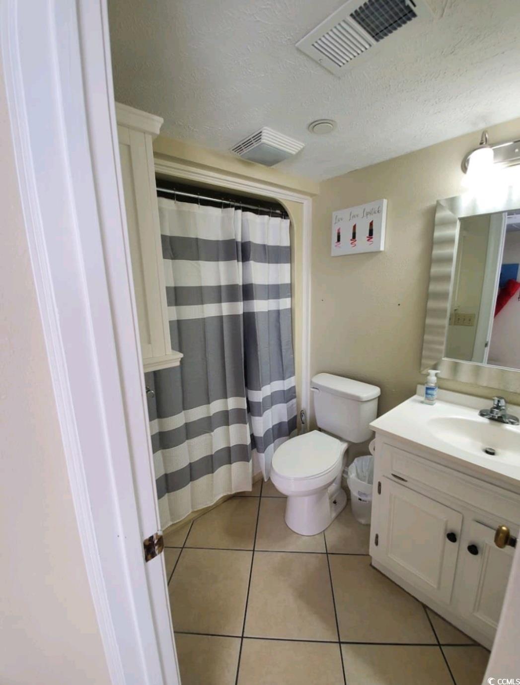 2000 South Ocean Boulevard, Unit V207AB Myrtle Beach, SC 29577 - Photo 5 of 11 Full bath with curtained shower, a textured ceiling, vanity, and light tile patterned floors