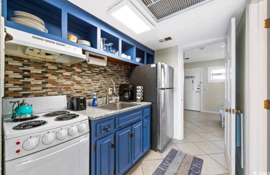 2000 South Ocean Boulevard, Unit V207AB Myrtle Beach, SC 29577 - Photo 8 of 11 Kitchen featuring blue cabinets, white electric range oven, light countertops, under cabinet range hood, and open shelves