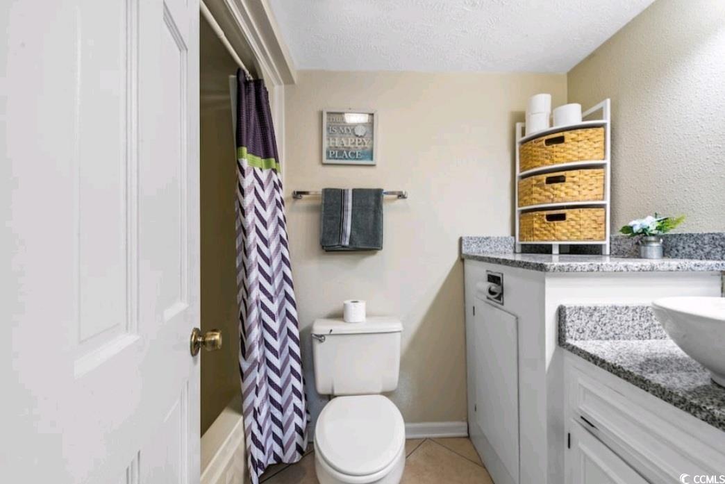 2000 South Ocean Boulevard, Unit V207AB Myrtle Beach, SC 29577 - Photo 9 of 11 Full bath with vanity, light tile patterned floors, shower / bathtub combination with curtain, a textured ceiling, and a textured wall