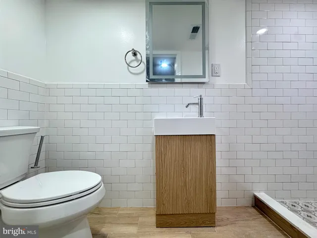 a bathroom with a toilet a sink and mirror