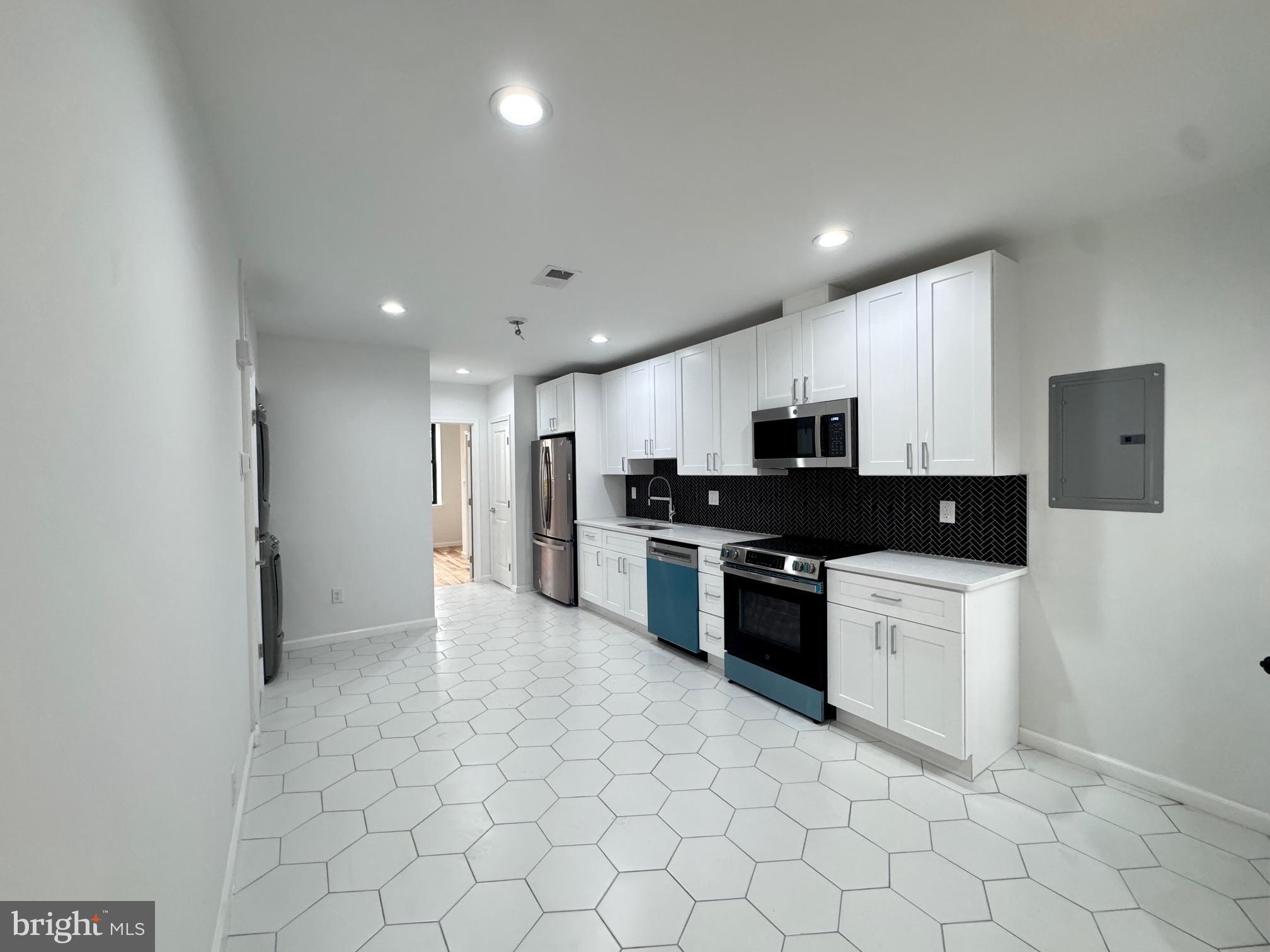 781 South 3rd Street, Unit 3 Philadelphia, PA 19147 - Photo 6 of 17 a kitchen with granite countertop a refrigerator and a stove top oven