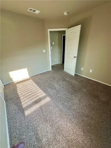 an empty room with an entryway and closet