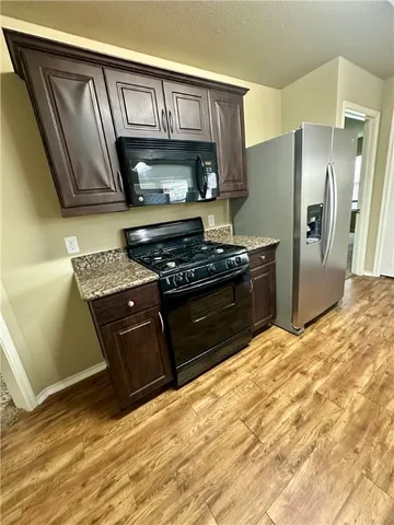 a kitchen with stainless steel appliances granite countertop a stove a sink and a refrigerator