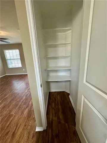 a view of a hallway with wooden floor and a closet
