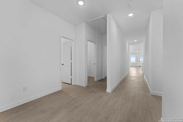 a view of a hallway with wooden floor