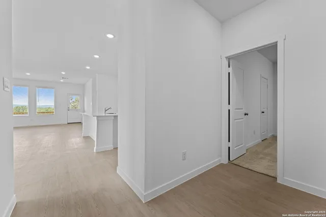 an empty room with a kitchen and a window