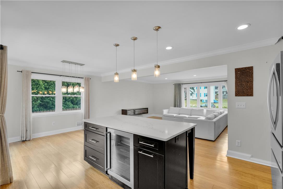 3396 Darien Road Bethlehem, PA 18020 - Photo 15 of 44 Natural light floods this inviting living area, showcasing gleaming hardwood floors and stylish pendant lighting.