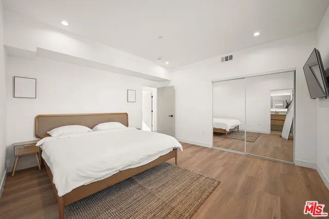 a bedroom with a bed and a flat screen tv