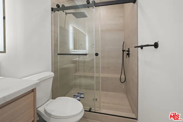 a bathroom with a shower a toilet and a sink