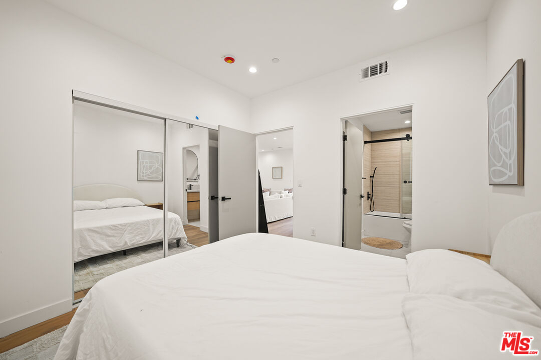13692 Erwin Street, Unit A Van Nuys, CA 91401 - Photo 16 of 47 a bedroom with a bed and a large mirror