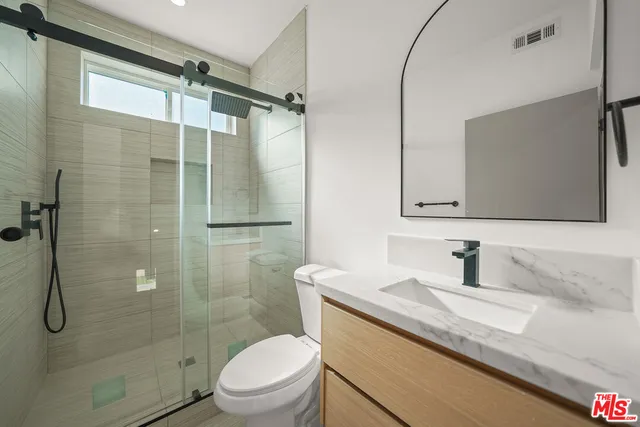 a bathroom with a granite countertop sink toilet and shower