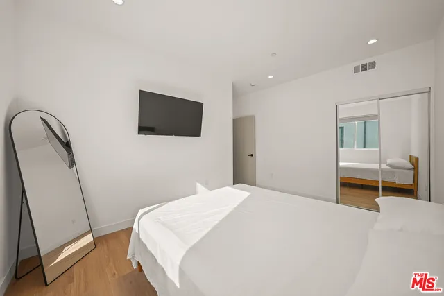 a bedroom with a bed and a flat screen tv