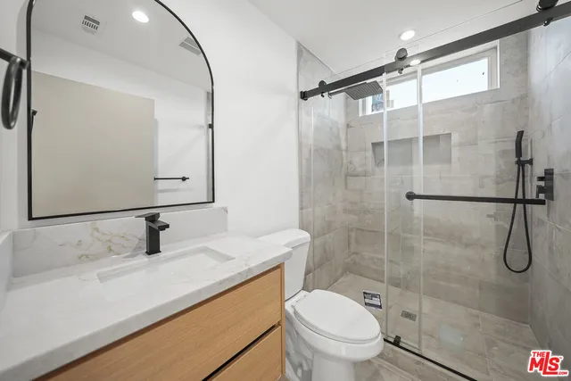 a bathroom with a granite countertop sink toilet and shower