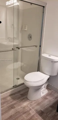 a white toilet sitting next to a shower