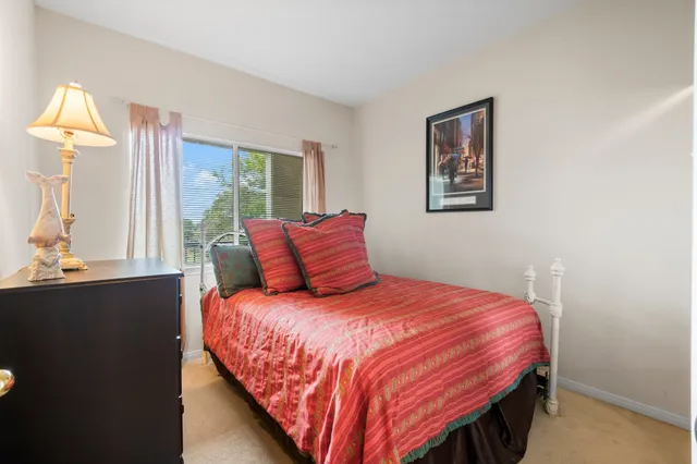 a bedroom with a bed wooden floor and window