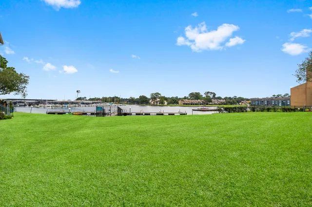 a view of a house with a big yard and large trees