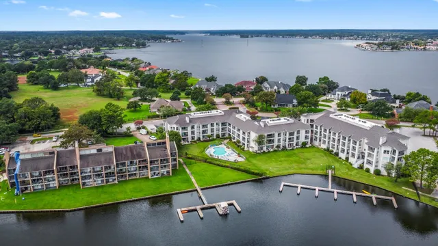 an aerial view of a house with a yard and lake view