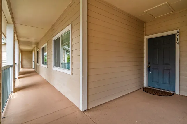 a view of a hallway with wooden floor and a living room