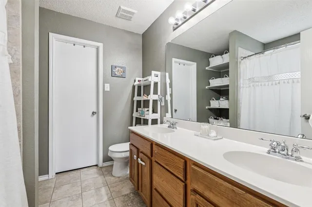 a bathroom with a double vanity sink toilet and shower