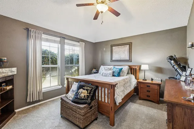 a spacious bedroom with a bed a couch and a chandelier