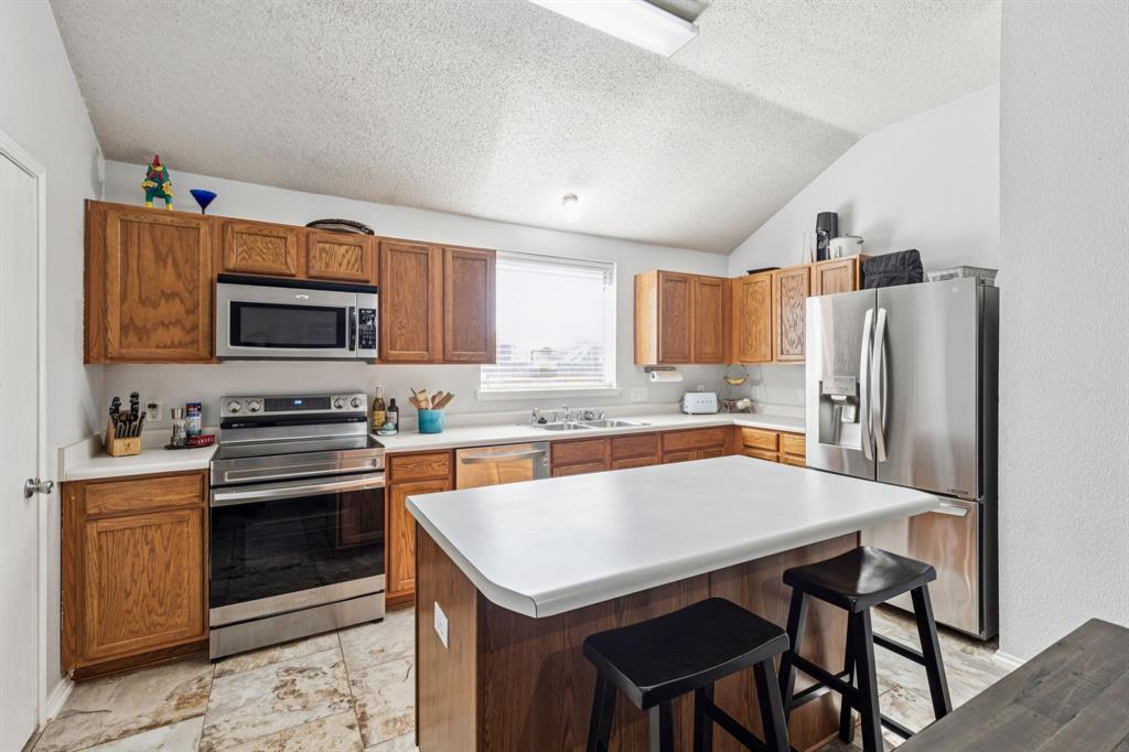 1421 Heather Ridge Drive Lancaster, TX 75146 - Photo 7 of 22 a kitchen with stainless steel appliances a stove a sink dishwasher and a refrigerator