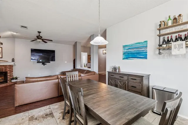 a kitchen with stainless steel appliances granite countertop a dining table chairs and a refrigerator