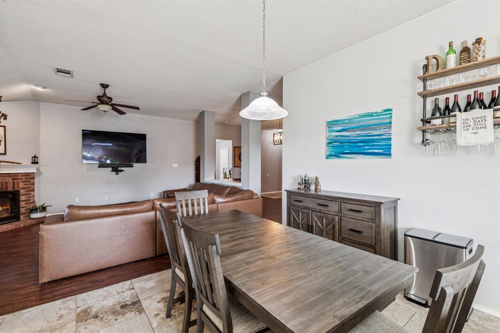 1421 Heather Ridge Drive Lancaster, TX 75146 - Photo 9 of 22 a kitchen with stainless steel appliances granite countertop a dining table chairs and a refrigerator