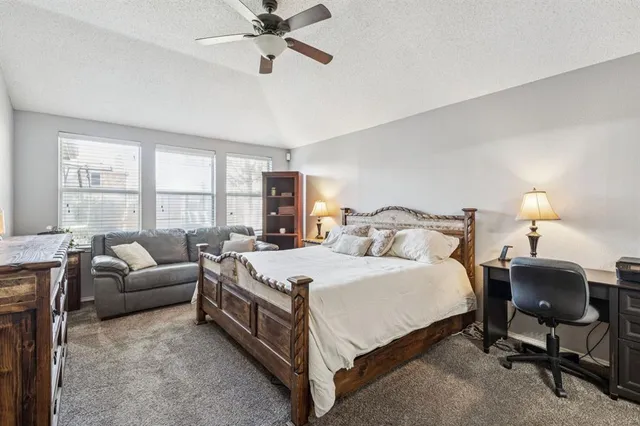 a spacious bedroom with a bed a couch and a window