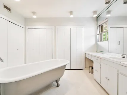 a white toilet sitting next to a white wall